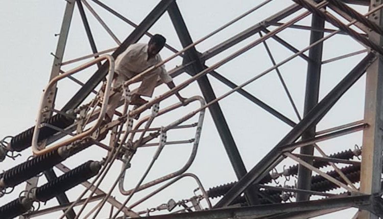 హై టెన్షన్‌ విద్యుత్‌ స్తంభం ఎక్కి యువకుడి హల్‌చల్‌