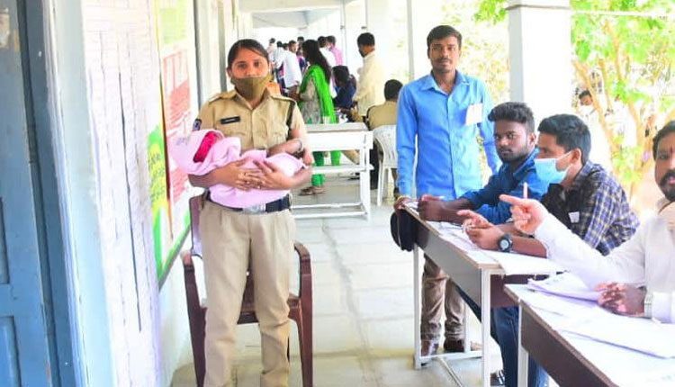 తల్లి పోలింగ్‌ బూత్‌లో..బిడ్డ కానిస్టేబుల్‌ ఒడిలో