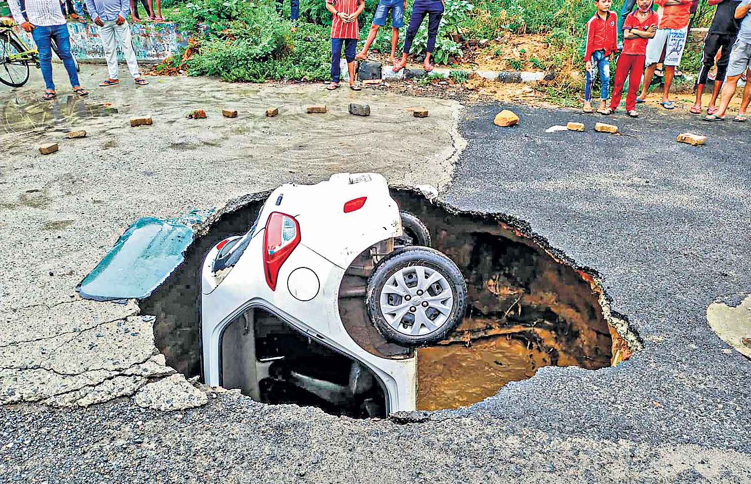 రోడ్డు కుంగింది.. కారును మింగింది!