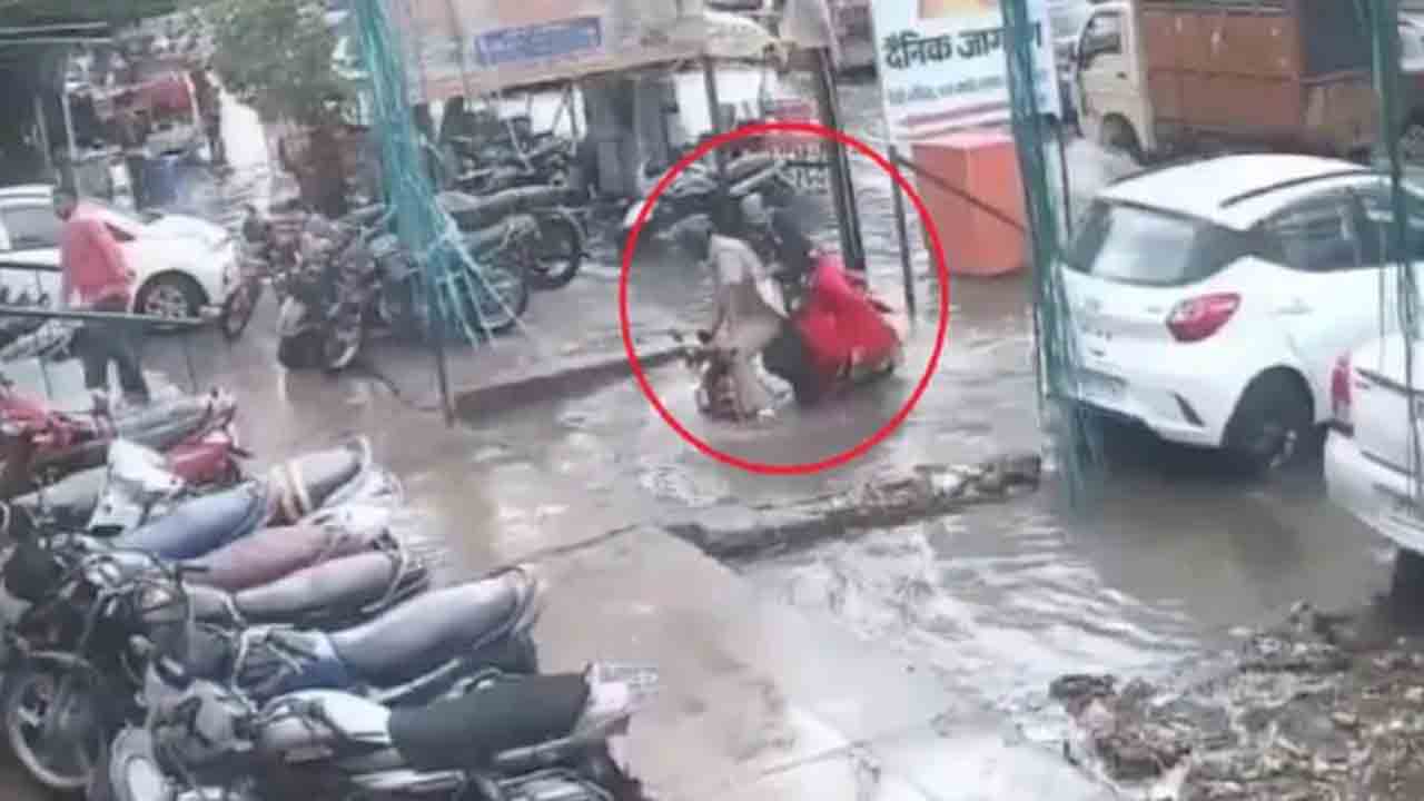 WATCH: స్కూటీపై వెళ్తూ నీటి గుంతలో పడిన జంట… ఎక్కడంటే?
