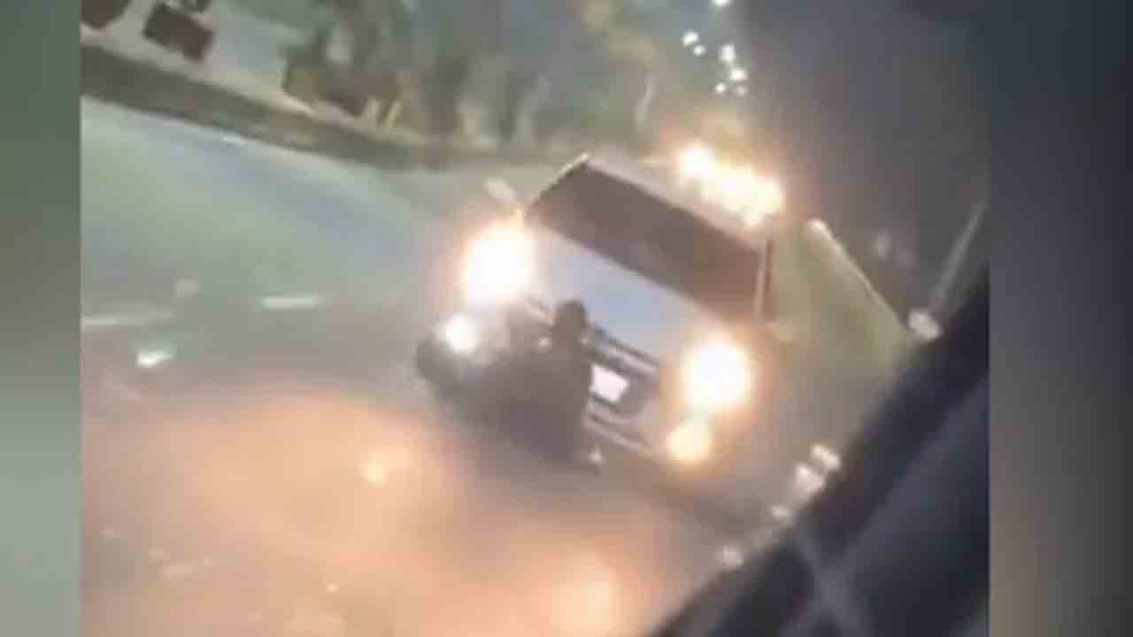 Car Runs Over Man | రోడ్డుపై కూర్చొన్న వ్యక్తి.. బీజేపీ జెండా ఉన్న కారు ఢీకొట్టి ఈడ్చుకెళ్లడంతో మృతి