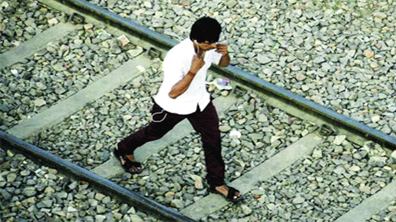 ఇయర్‌ ఫోన్స్‌ పెట్టుకొని పట్టాల వెంట నడుస్తూ..