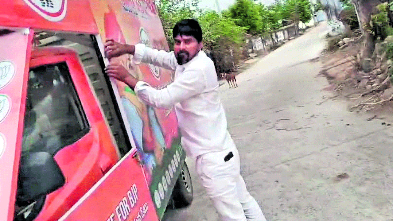 బీజేపీ ఫ్లెక్సీ చింపిన కాంగ్రెస్‌ నాయకుడు