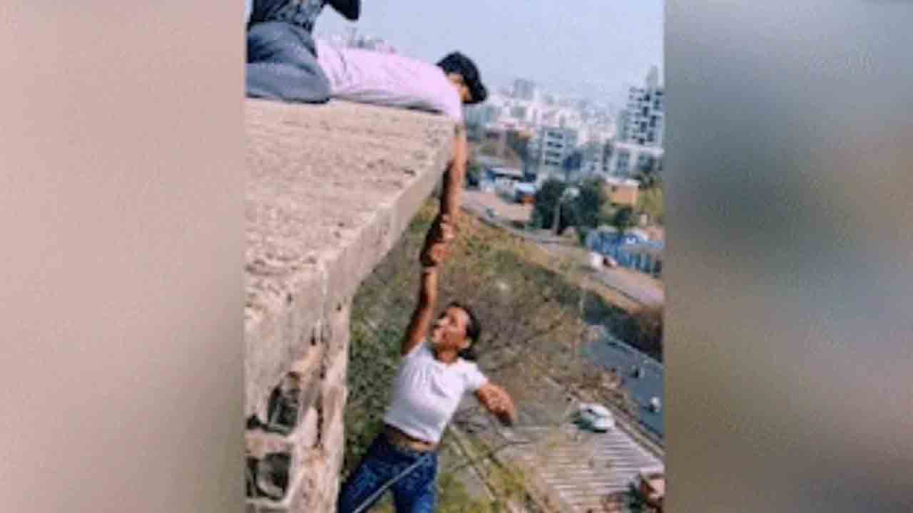 Watch: రీల్‌ కోసం పాట్లు.. బిల్డింగ్‌ అంచు నుంచి ప్రమాదకరంగా వేలాడిన యువతి