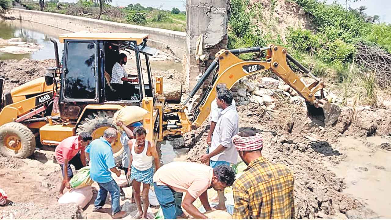 శ్రమదానం చేసి.. గండిని పూడ్చేసి