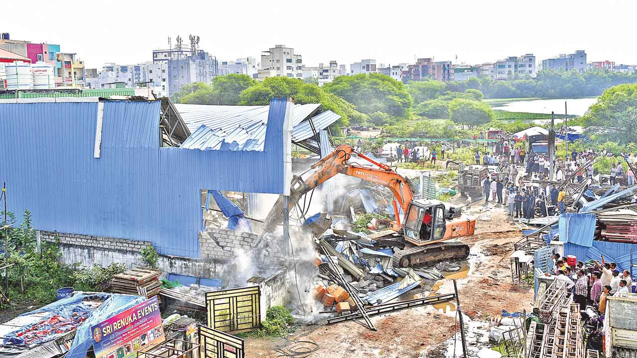 అనుమతులను గౌరవిస్తం.. రద్దు చేసి కూల్చేస్తం.. ఒకే వేదికపై ఇద్దరు అధికారుల విరుద్ధ ప్రకటన