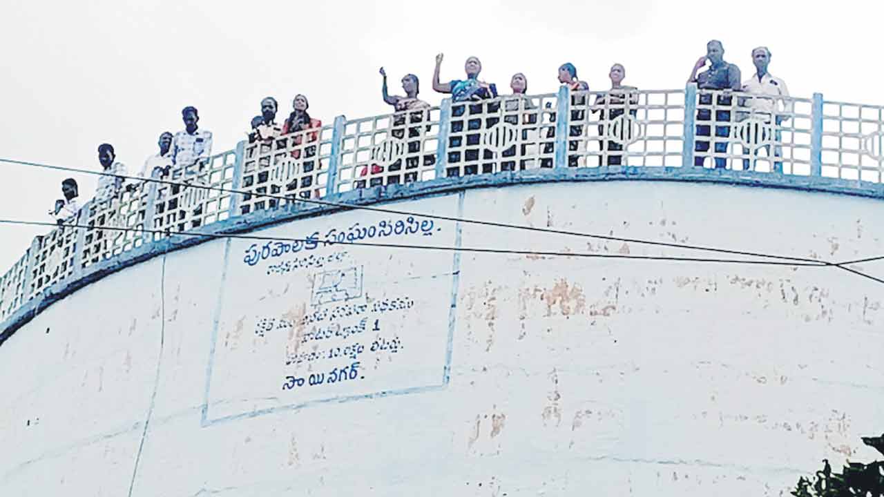 వాటర్‌ ట్యాంకు ఎక్కి ఆందోళన చేస్తున్న తాజా మాజీ రేషన్‌ డీలర్లు