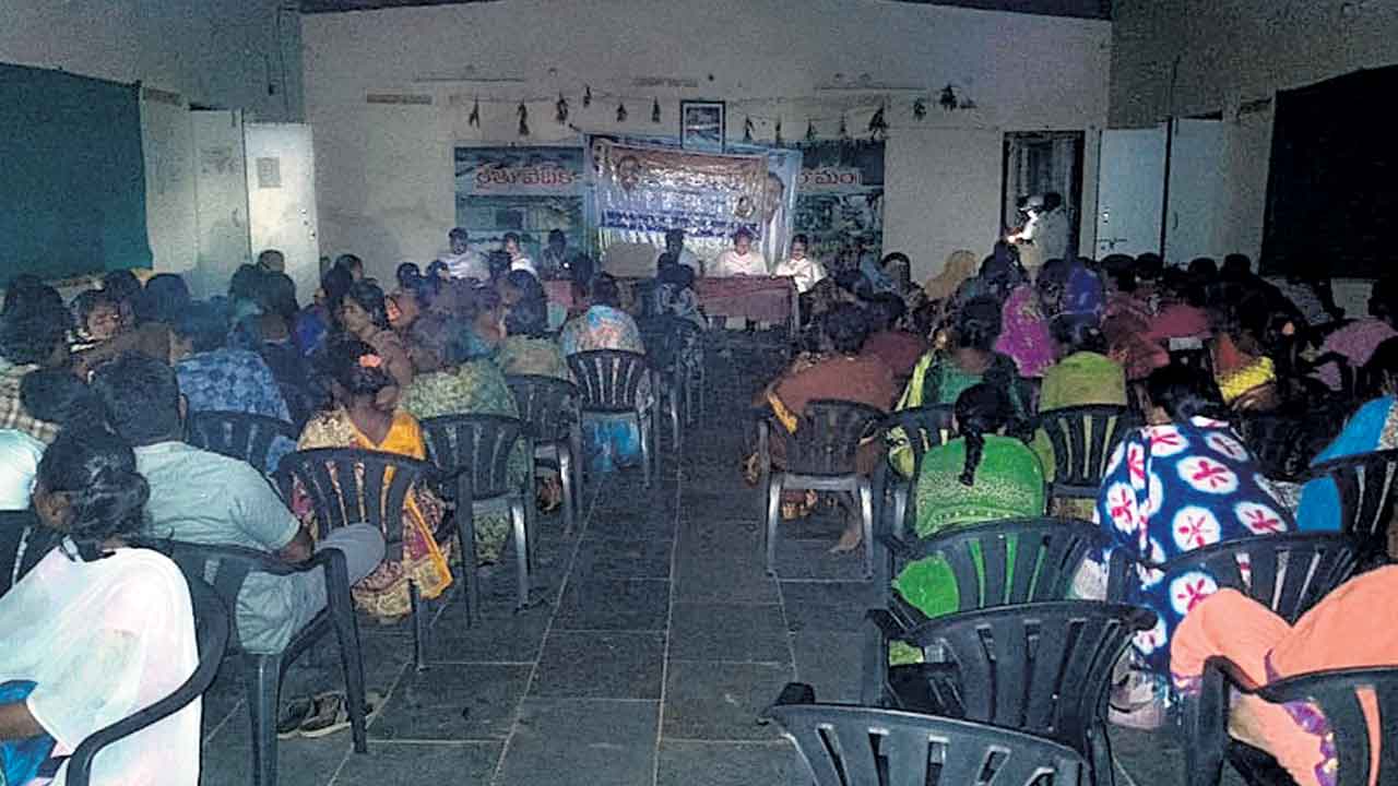 సెల్‌ఫోన్ వెలుతురులో చెక్కుల పంపిణీ