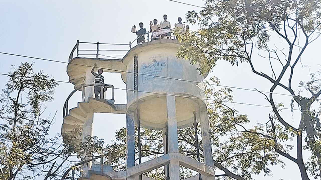 పట్టాలివ్వాలని ట్యాంక్‌ ఎక్కిన రైతులు