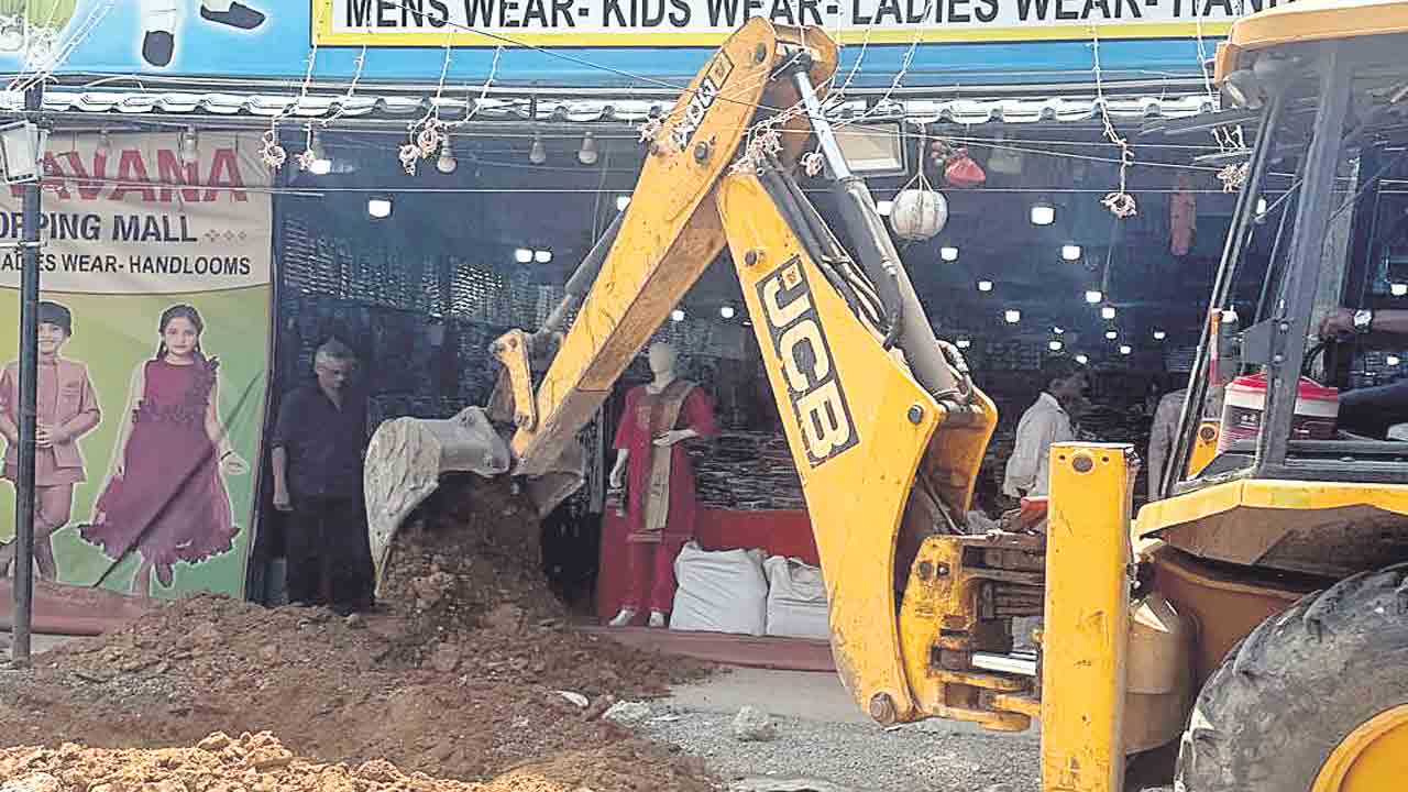 ఆస్తి పన్ను కట్టలేదని.. షాపు ముందు గుంత తవ్వారు