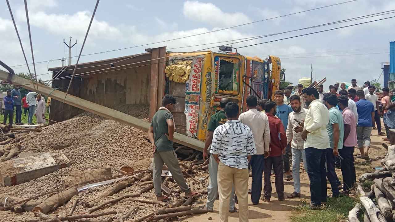 Gravel lorry Overturns | విద్యుత్ స్తంభాన్ని ఢీకొట్టి కంకర లారీ బోల్తా