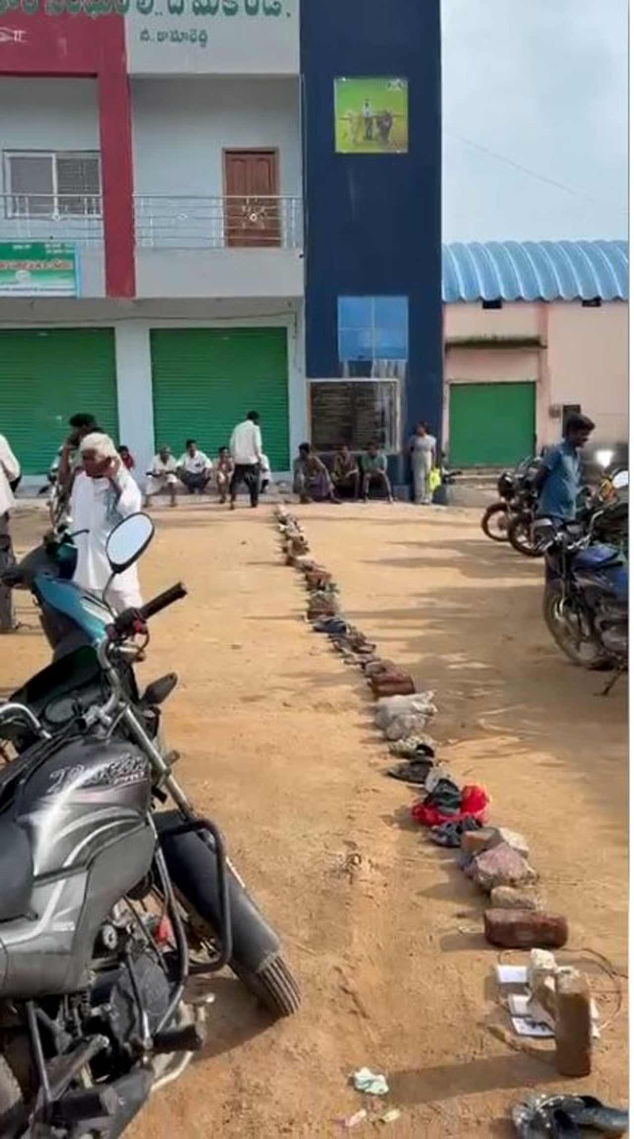  కామారెడ్డి జిల్లా దోమకొండ వ్యవసాయ సహకార సంఘం ఎదుట వరుసలో పెట్టిన చెప్పులు
