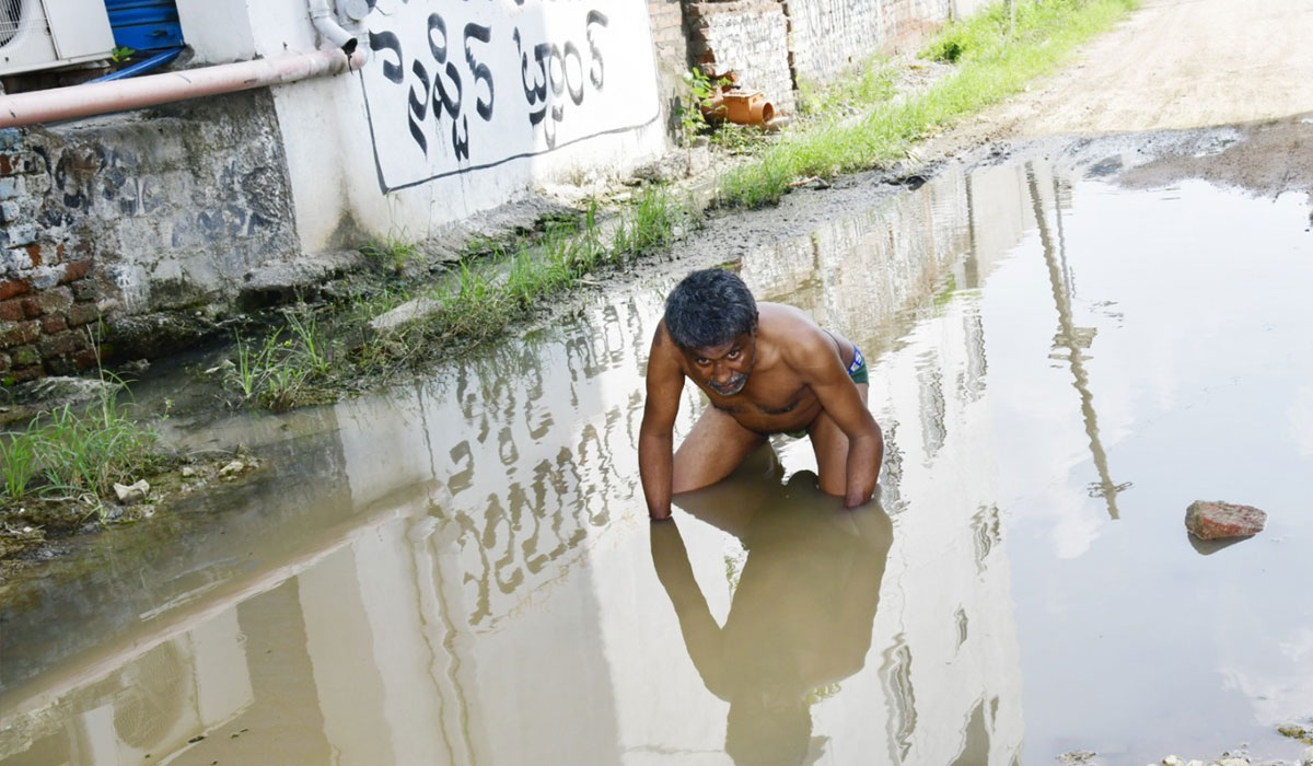 Drainage | చిన్నముల్కనూరులో డ్రైనేజీ శుభ్రం చేయడం లేదని మురుగు నీటిలో వ్యక్తి నిరసన
