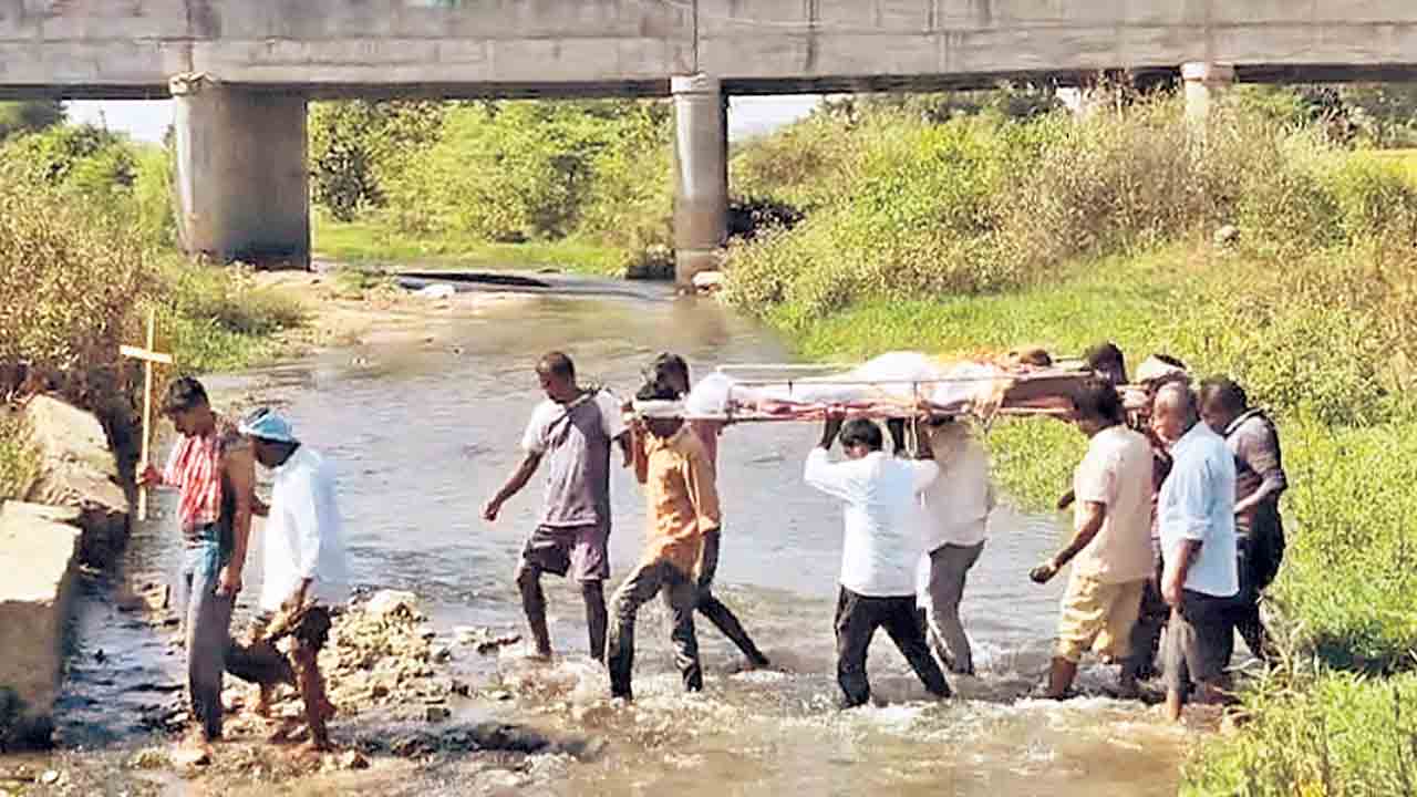 వాగు దాటుతూ.. సైడ్‌వాల్‌ ఎక్కుతూ!