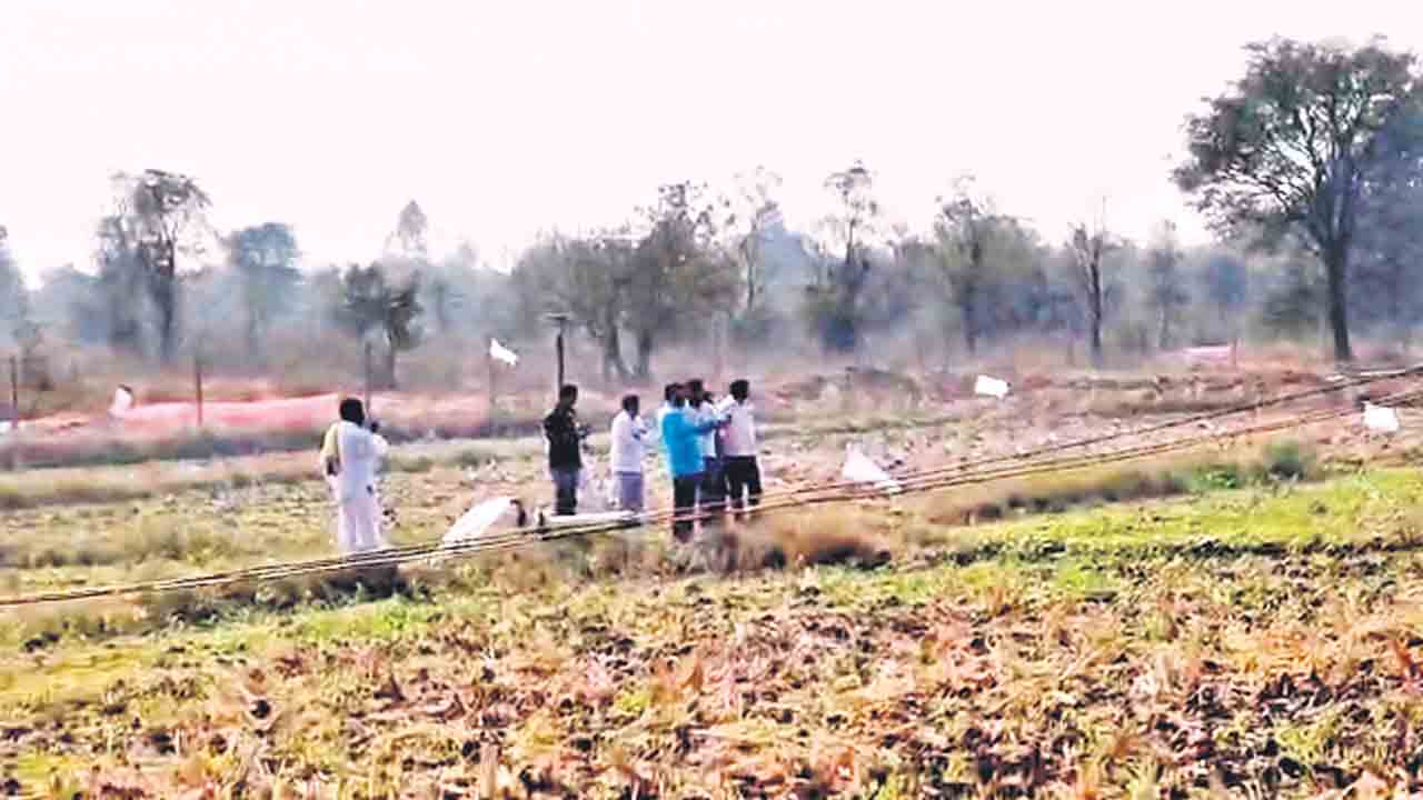 రుణం చెల్లించలేదని పొలం వేలానికి.. జెండాలు పాతిన సహకార బ్యాంక్‌ అధికారులు
