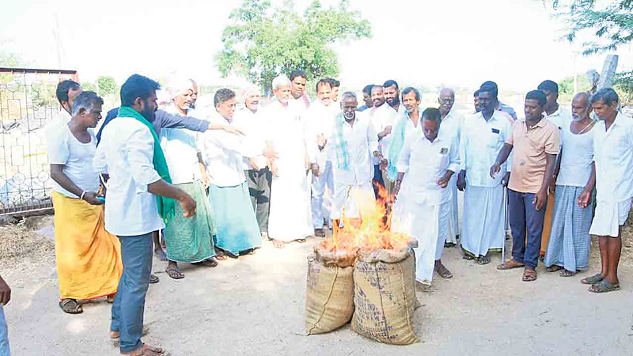 ధాన్యం బస్తాలకు నిప్పు!.. ధాన్యం కొనుగోళ్లు చేపట్టాలంటూ మల్లాపురంలో రైతుల వినూత్న నిరసన
