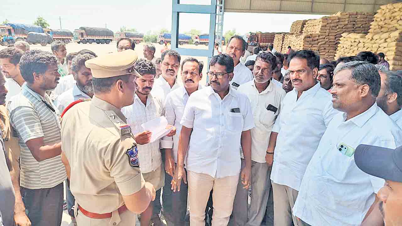 కుర్చీ వేసుకొని కూర్చొని.. ధాన్యం బస్తాలు అన్‌లోడింగ్‌