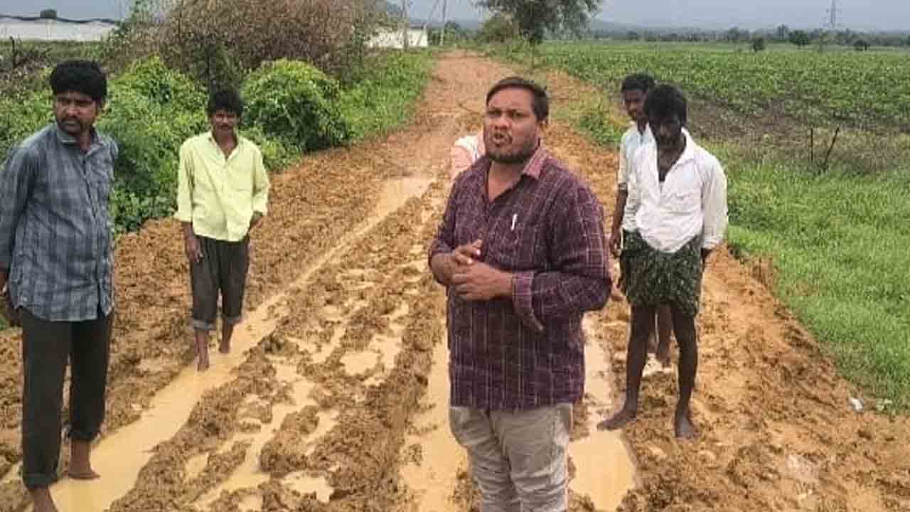 Road repairs | రోడ్డు వేయాలని బురదలో నిలబడి రైతుల నిరసన