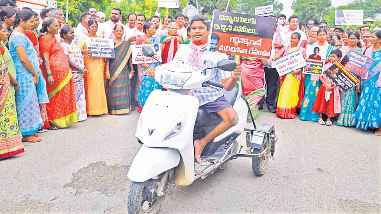 సిరిసిల్ల జిల్లా బోయినపల్లిలో ‘హామీల అమలేది?’ అంటూ ప్లకార్డు ప్రదర్శిస్తున్న దివ్యాంగుడు ఎల్లయ్య 